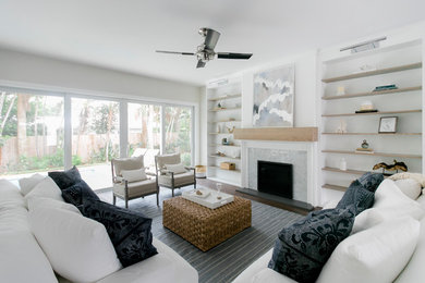 Living room - coastal open concept dark wood floor and brown floor living room idea in Miami with gray walls and a stone fireplace