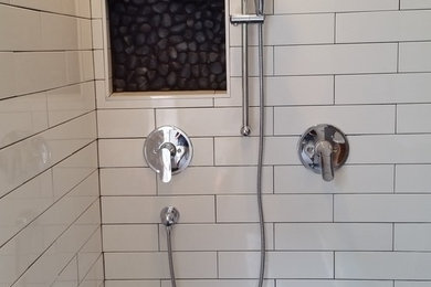 Inspiration for a mid-sized transitional white tile and ceramic tile pebble tile floor and brown floor bathroom remodel in Jacksonville