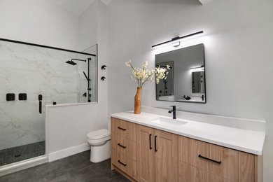 This is an example of a large scandinavian master bathroom in Tampa with flat-panel cabinets, light wood cabinets, a double shower, a one-piece toilet, white tile, porcelain tile, white walls, porcelain floors, an undermount sink, engineered quartz benchtops, grey floor, a hinged shower door, white benchtops, a niche, a double vanity and vaulted.