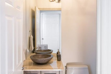 Inspiration for a country powder room in Tampa with a vessel sink, quartzite benchtops and pebble tile floors.