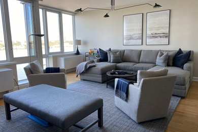 Example of a mid-sized transitional open concept medium tone wood floor living room design in New York with gray walls and a tv stand