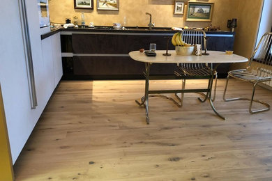 Foto di una grande cucina abitabile classica con ante lisce, ante marroni, top in superficie solida, paraspruzzi giallo, pavimento in legno massello medio, pavimento beige e top marrone