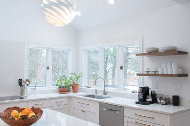Inspiration for a transitional l-shaped dark wood floor, brown floor and vaulted ceiling kitchen remodel in Bridgeport with an undermount sink, shaker cabinets, white cabinets, quartz countertops, white backsplash, quartz backsplash, stainless steel appliances, an island and white countertops