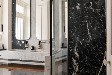Idée de décoration pour une grande salle de bain principale et grise et blanche avec un placard à porte plane, des portes de placard blanches, meuble-lavabo encastré, une douche à l'italienne, un carrelage blanc, du carrelage en marbre, un mur blanc, sol en béton ciré, un lavabo suspendu, un sol beige, aucune cabine, meuble double vasque et un mur en pierre.