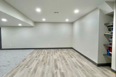 Ejemplo de sótano minimalista de tamaño medio con paredes beige, suelo vinílico y suelo gris