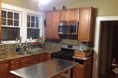 Enclosed kitchen - mid-sized traditional l-shaped medium tone wood floor enclosed kitchen idea in New York with an undermount sink, recessed-panel cabinets, medium tone wood cabinets, granite countertops, multicolored backsplash, mosaic tile backsplash, stainless steel appliances and an island