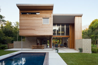 Example of a mid-sized trendy backyard concrete and rectangular lap pool design in New York