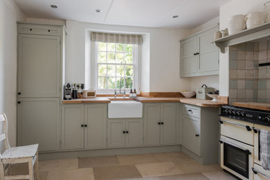 Country kitchen in Other with shaker cabinets, wood benchtops and ceramic floors.