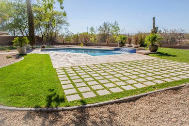 Example of a large backyard custom-shaped lap pool fountain design in Phoenix