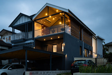 This is an example of a mid-sized contemporary two-storey multi-coloured duplex exterior in Sydney with wood siding, a gable roof and a metal roof.