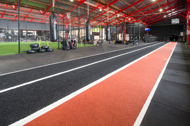 Expansive contemporary multipurpose gym in Sydney with black walls and black floor.