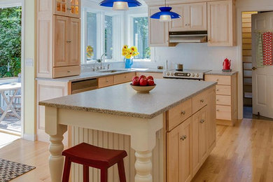 Example of a large u-shaped light wood floor open concept kitchen design in Portland Maine with a double-bowl sink, light wood cabinets, granite countertops, stainless steel appliances and an island