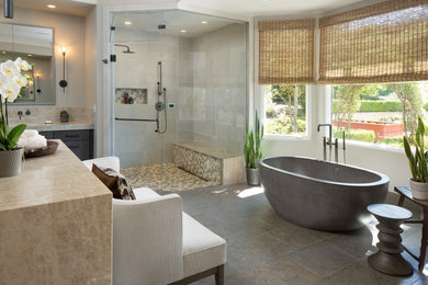 This is an example of an expansive contemporary ensuite bathroom in San Diego with flat-panel cabinets, dark wood cabinets, a freestanding bath, a built-in shower, a submerged sink, marble worktops, a hinged door, a shower bench, a single sink, a floating vanity unit, grey tiles, ceramic tiles, ceramic flooring and beige worktops.