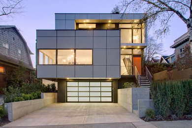 Example of a large trendy gray three-story metal flat roof design in Seattle