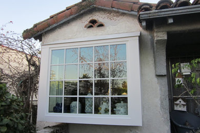 Photo of a small mediterranean one-storey stucco white exterior in Los Angeles with a gable roof.
