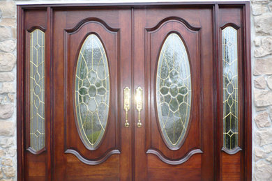 Example of a large concrete floor entryway design in New York with beige walls and a dark wood front door