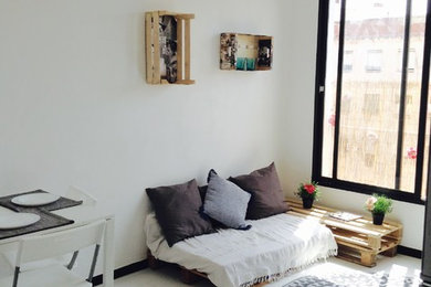 Modelo de sala de estar abierta escandinava pequeña con paredes blancas, suelo laminado, televisor colgado en la pared y suelo blanco