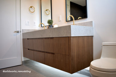 Photo of a small modern ensuite bathroom in Los Angeles with flat-panel cabinets, dark wood cabinets, a corner shower, a one-piece toilet, black tiles, porcelain tiles, white walls, porcelain flooring, a built-in sink, quartz worktops, black floors, grey worktops, a wall niche, double sinks and a floating vanity unit.