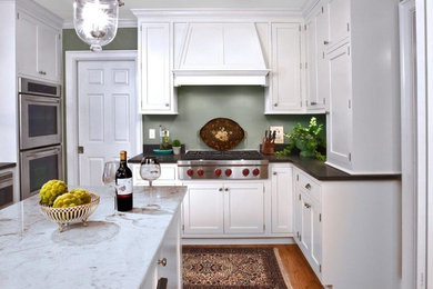 Enclosed kitchen - mid-sized cottage l-shaped medium tone wood floor and brown floor enclosed kitchen idea in Chicago with shaker cabinets, white cabinets, solid surface countertops, stainless steel appliances and an island