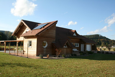 Idées déco pour une grande façade de maison beige montagne en bois à un étage avec un toit de Gambrel et un toit en tuile.