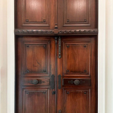 We are designers and builders of carved wood doors with wrought metal appliqués.