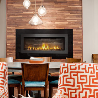 Foto de sótano en el subsuelo clásico renovado, grande, con paredes grises, chimenea lineal, marco de chimenea de metal y suelo marrón