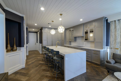 Inspiration for a transitional porcelain tile kitchen remodel in Miami with gray cabinets, quartz countertops, white backsplash, subway tile backsplash, paneled appliances, an island and white countertops