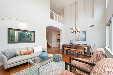 Inspiration for a contemporary formal and open concept medium tone wood floor and brown floor living room remodel in San Diego with white walls and no tv