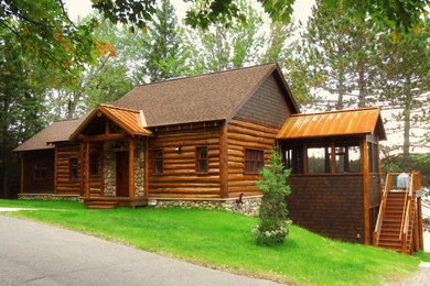 Example of a large mountain style brown two-story wood exterior home design in Other with a shingle roof