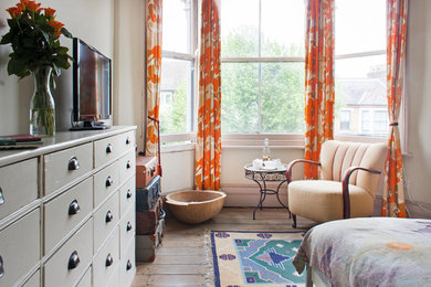 Design ideas for a medium sized eclectic bedroom in London with light hardwood flooring, no fireplace and brown floors.