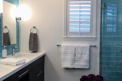 Mid-sized transitional master blue tile and glass tile porcelain tile and brown floor bathroom photo in San Francisco with recessed-panel cabinets, dark wood cabinets, white walls and quartz countertops
