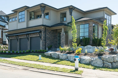 Inspiration for a large modern brown two-story concrete fiberboard house exterior remodel in Vancouver with a clipped gable roof and a mixed material roof