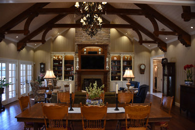 Inspiration for a large timeless open concept medium tone wood floor family room remodel in Austin with beige walls, a standard fireplace, a wood fireplace surround and a wall-mounted tv