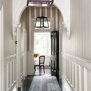 Exempel på en mellanstor klassisk hall, med vita väggar, mörkt trägolv och svart golv