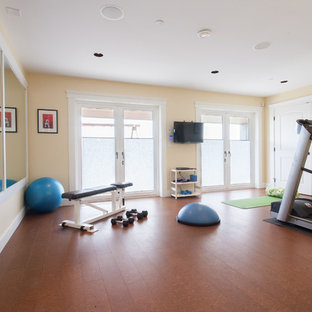 バンクーバーのトラディショナルスタイルのおしゃれな多目的ジム (黄色い壁、茶色い床) の写真