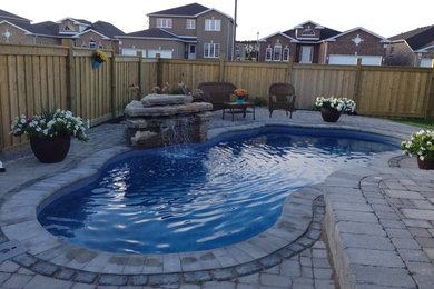Design build fiberglass pool with a water feature.