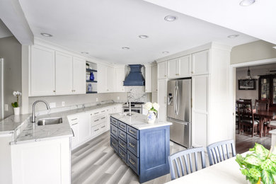 Mid-sized transitional u-shaped laminate floor and gray floor open concept kitchen photo in DC Metro with an undermount sink, shaker cabinets, white cabinets, quartzite countertops, stainless steel appliances, an island and white countertops