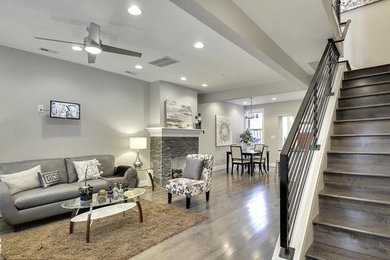 Mid-sized minimalist open concept medium tone wood floor and gray floor family room photo in DC Metro with gray walls and a wall-mounted tv