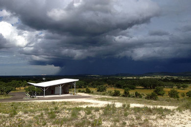 Large contemporary gray one-story concrete exterior home idea in Austin with a shed roof