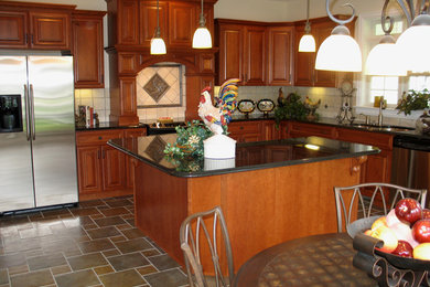 Example of a large classic galley ceramic tile eat-in kitchen design in Other with a double-bowl sink, medium tone wood cabinets, granite countertops, multicolored backsplash, mirror backsplash, stainless steel appliances, an island and raised-panel cabinets