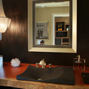 Immagine di un piccolo bagno di servizio minimalista con ante nere, pareti marroni, lavabo a bacinella, top in legno, ante a filo, piastrelle marroni e piastrelle in gres porcellanato