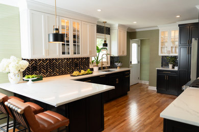 Eat-in kitchen - mid-sized transitional medium tone wood floor and brown floor eat-in kitchen idea in New York with an undermount sink, shaker cabinets, black cabinets, quartz countertops, black backsplash, porcelain backsplash, stainless steel appliances, a peninsula and multicolored countertops