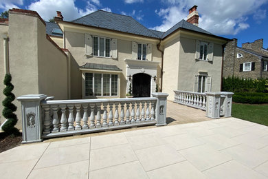 Example of a mid-sized french country front yard stone patio design in Philadelphia with no cover