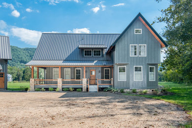 Mid-sized cottage blue two-story wood exterior home photo in Other with a metal roof