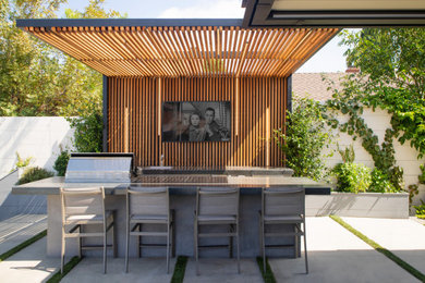 Diseño de patio contemporáneo de tamaño medio en patio trasero con huerto, adoquines de hormigón y pérgola
