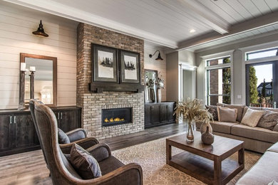This is an example of a country living room in Boise with grey walls, dark hardwood floors, a ribbon fireplace, a brick fireplace surround and brown floor.