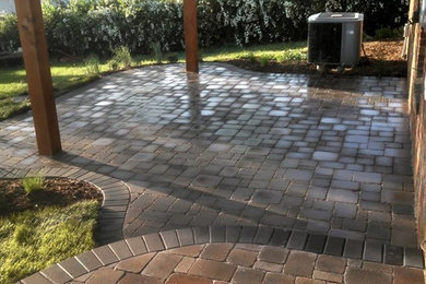 Patio - large backyard brick patio idea in Omaha with a pergola