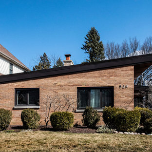 Idéer för små retro oranga hus, med tre eller fler plan, metallfasad och pulpettak