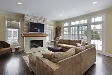 Living room - large traditional formal and open concept dark wood floor living room idea in Detroit with yellow walls, a standard fireplace, a stone fireplace and a wall-mounted tv