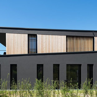 Einstöckiges, Schwarzes Modernes Haus mit Holzfassade und Flachdach in Berlin